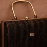 Trending Outfits - Vintage bag with golden handle placed on reflecting surface as accessory for garment