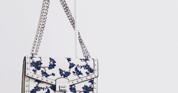 Fashion - White and Blue Floral Flap Sling Bag Hanging on White Steel Rack