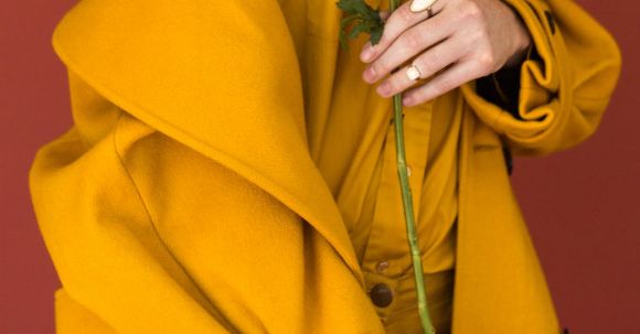 Fashion - Woman Wearing Yellow Trench Coat While Holding Purple Flower